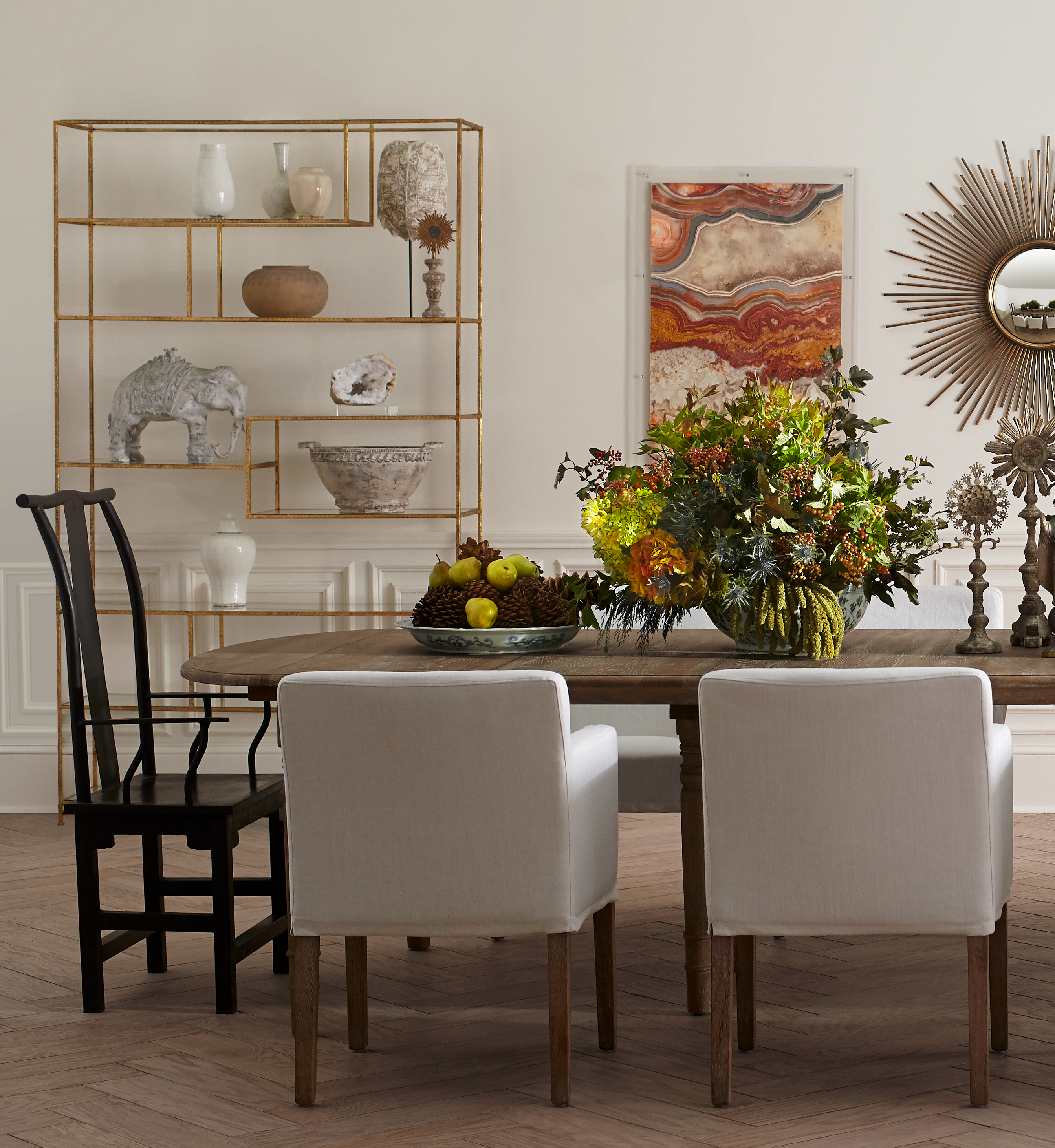 Expandable Oak Farmhouse Table – Elegant dining setup, large floral centerpiece, mixed seating styles.