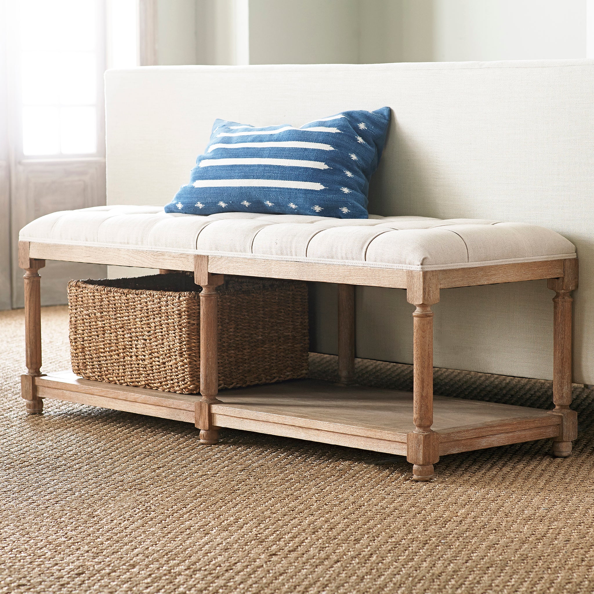 Chesterfield Bench – Stone cushion, natural wood, styled with blue pillow and basket in bright space.