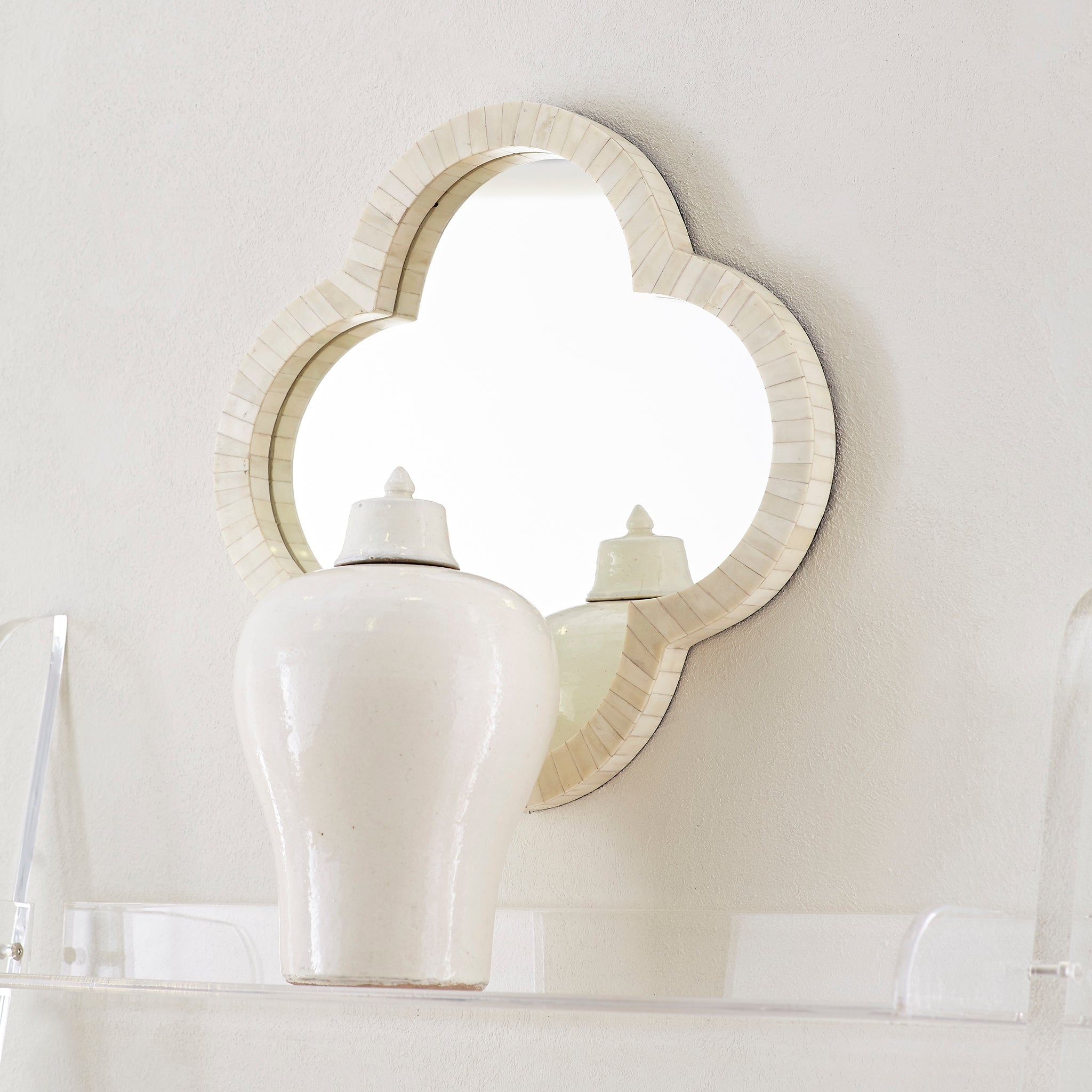 Clover Bone Mirror – styled on wall, reflected ceramic vase, soft lighting.