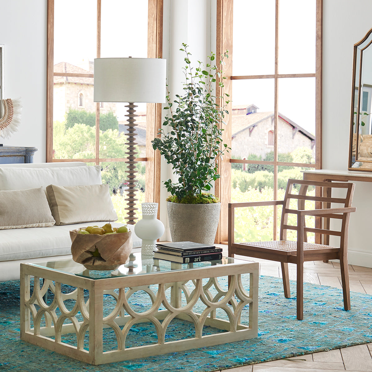 Lime Wash Coffee Table – Styled in a living room, placed on a blue rug, glass top.