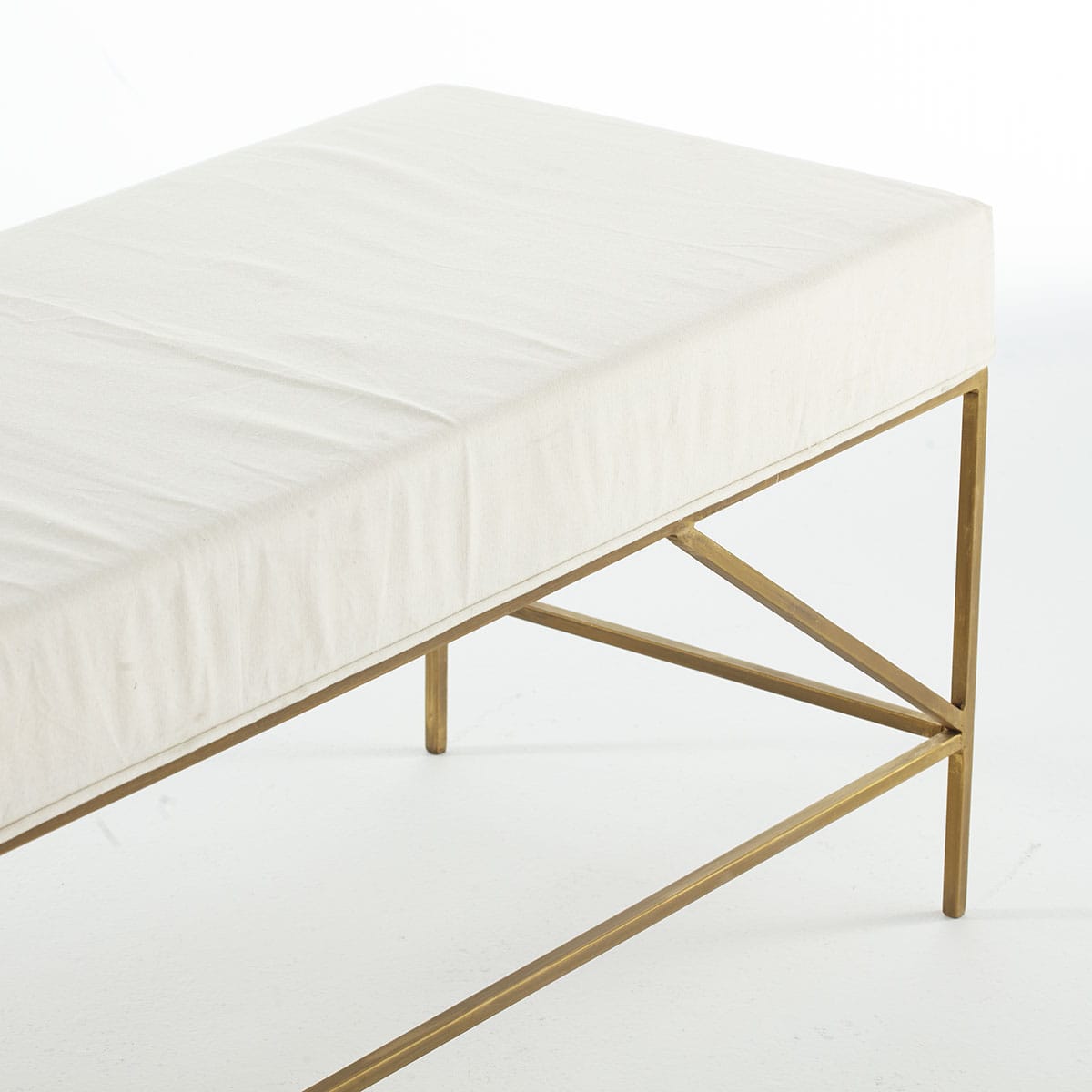Mid-Century Upholstered Bench – Close-up of gold frame, geometric support structure, white cushion.