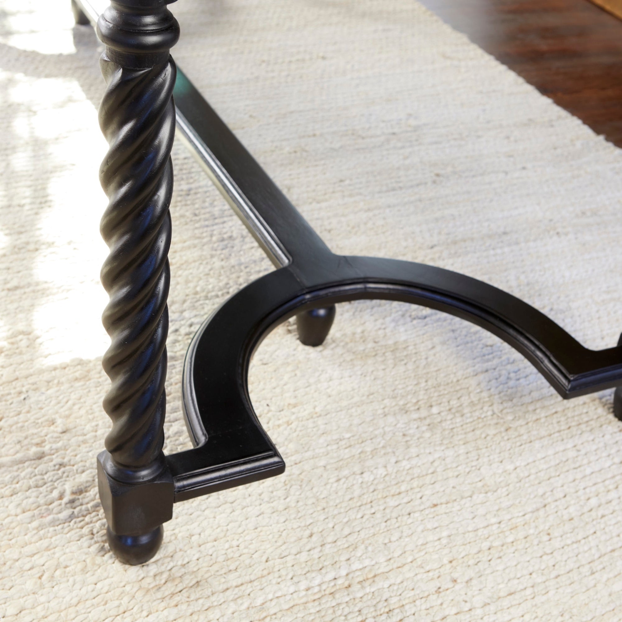 Barley Twist Desk – Black – close-up of curved stretcher on rug.
