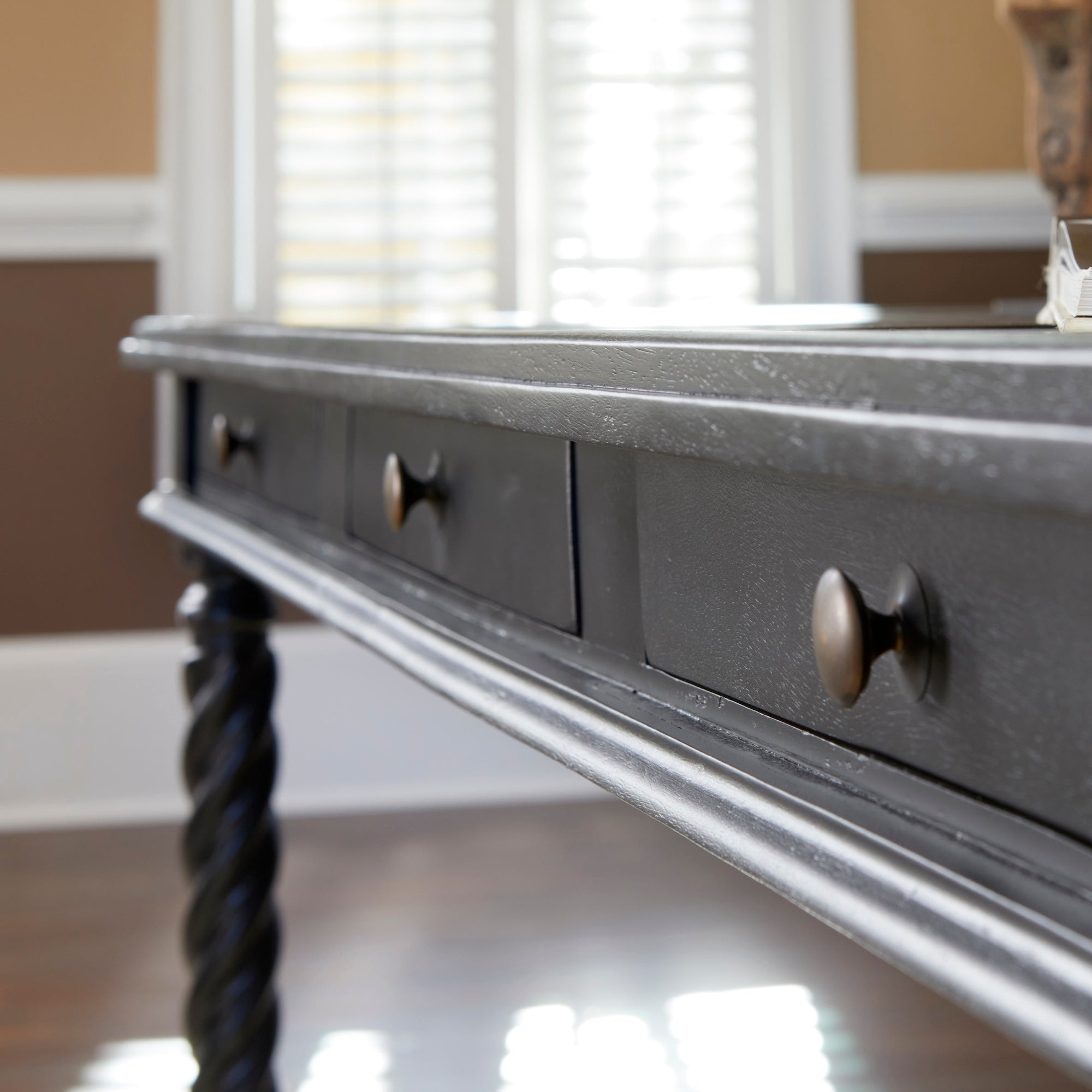 Barley Twist Desk – Black – angled view of drawers with background window.