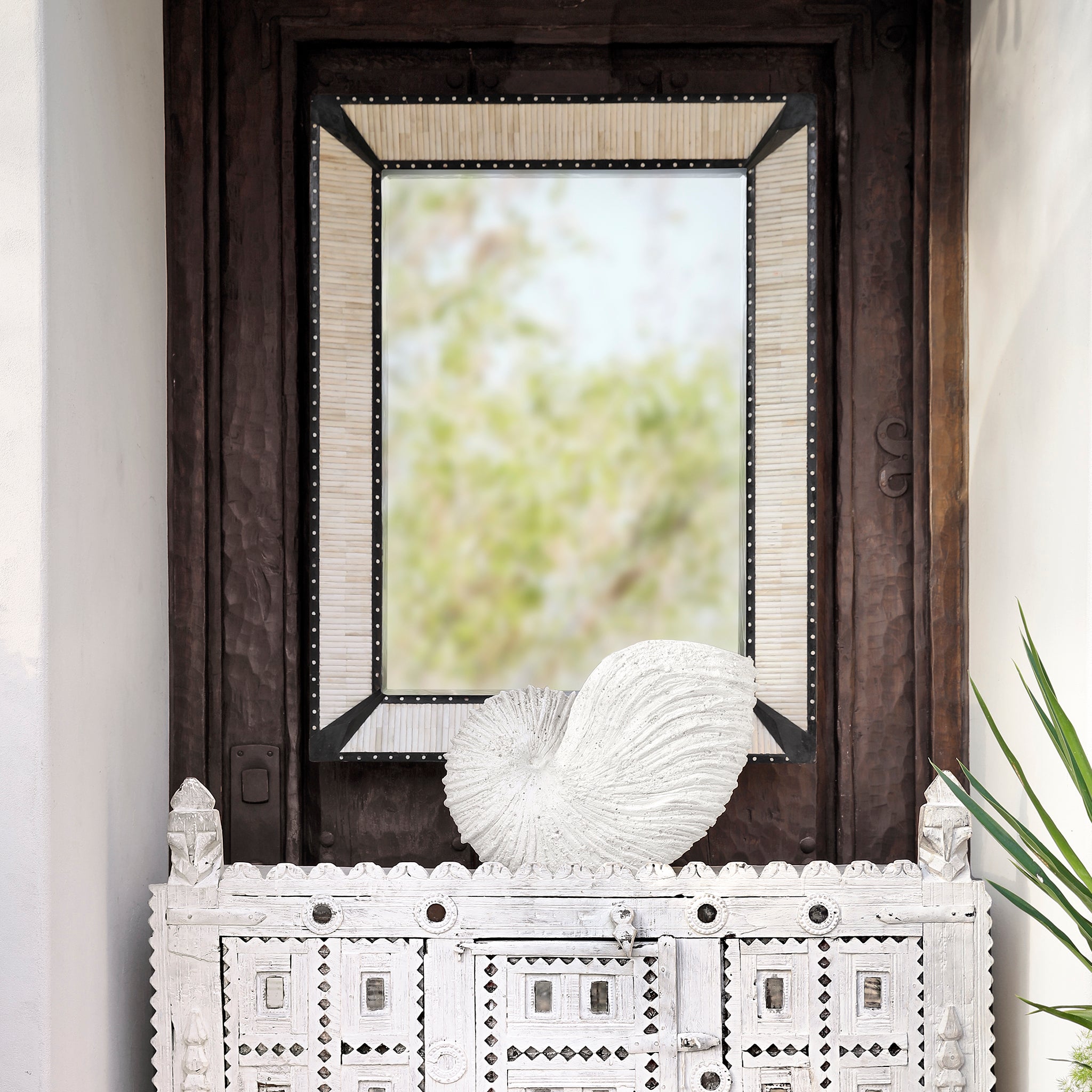 Hand-Carved Bone and Wood Mirror standing vertical on the Wall Above Console Table