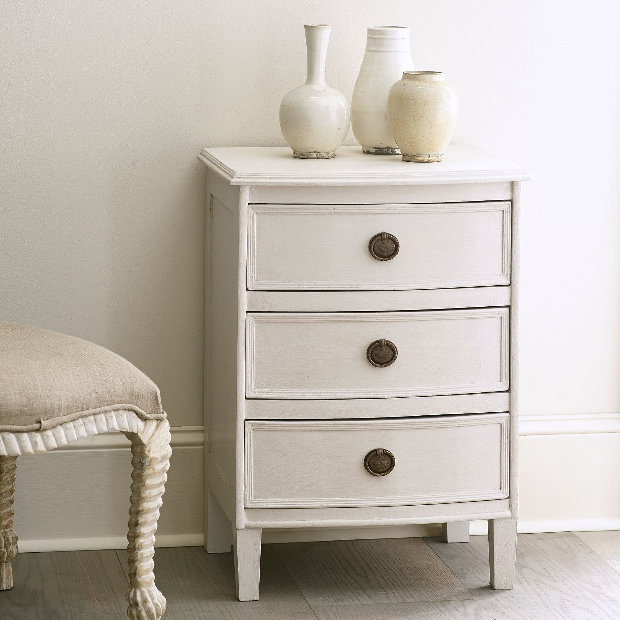 Kunj Three Drawer Chest – angled view, Ivory finish, brass drawer pulls, white background.