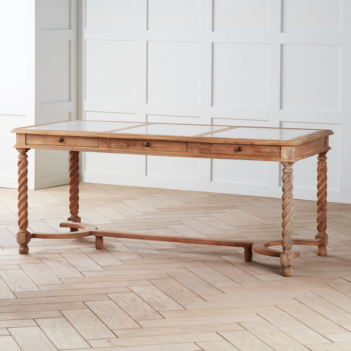 Barley Twist Desk – natural wood color, room setting, angled view with white panel wall.