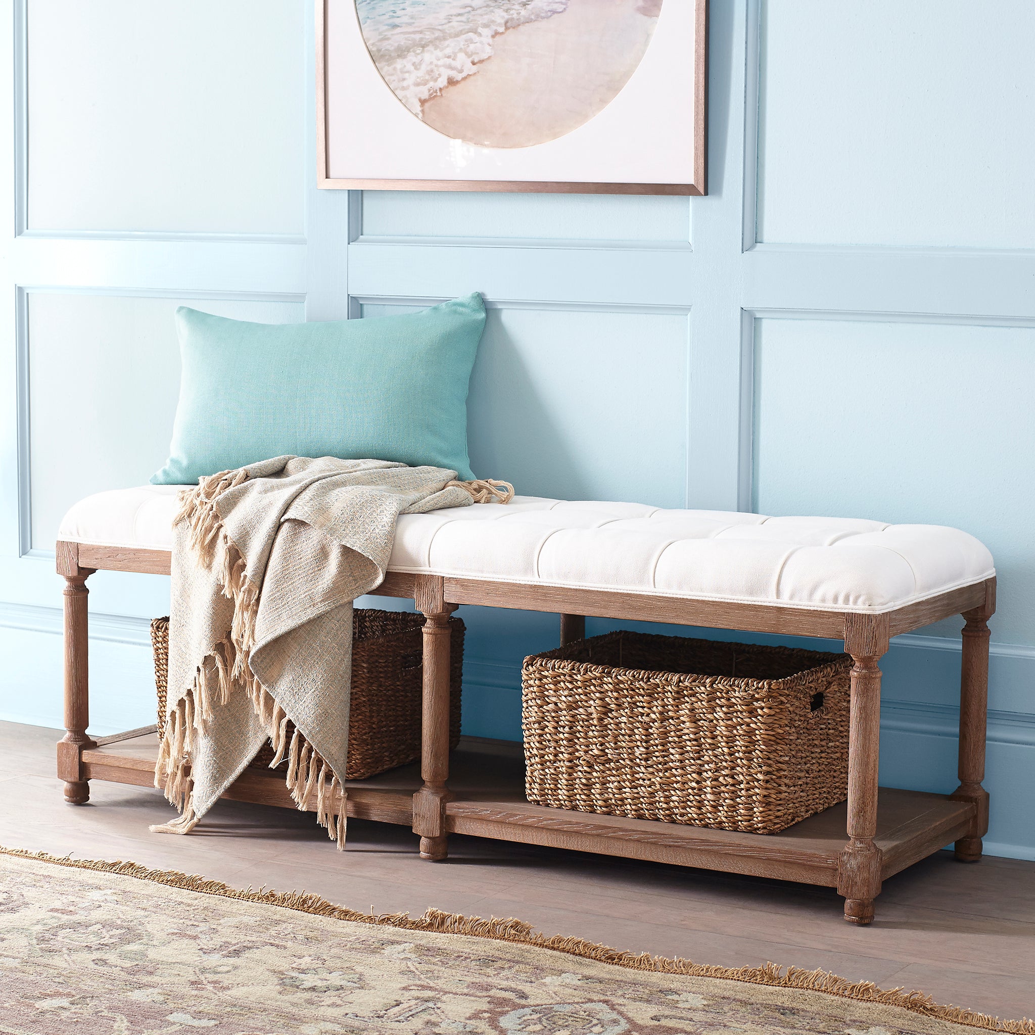 Chesterfield Bench in white – styled in entryway with blue pillow, beige throw, and woven baskets on lower shelf.