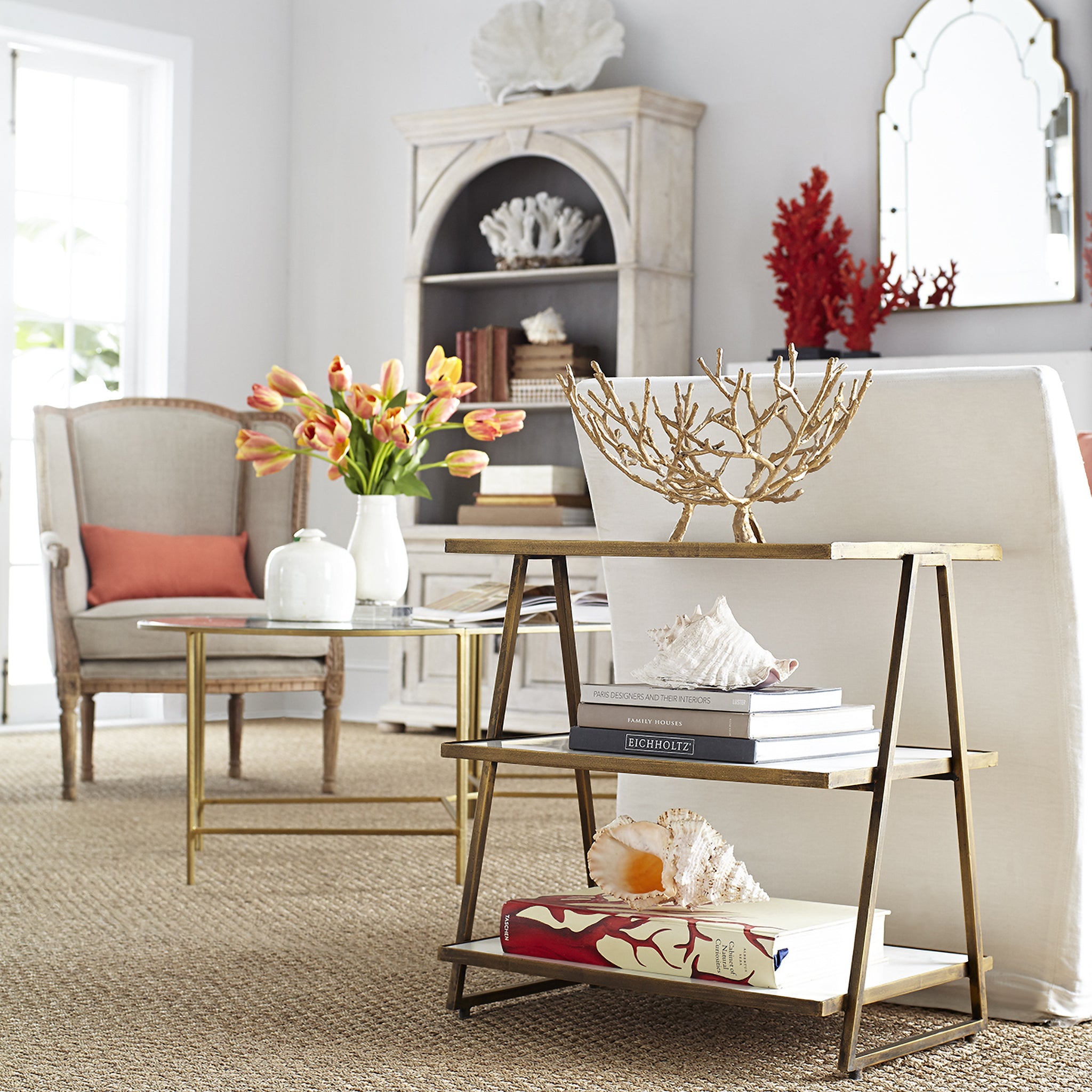 Three Tier Marble Top Table - angled view, coastal setting, blurred background.