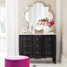 Black Serpentine Chest with Marble Top in a Living Room Setting with a Mirror in the Background