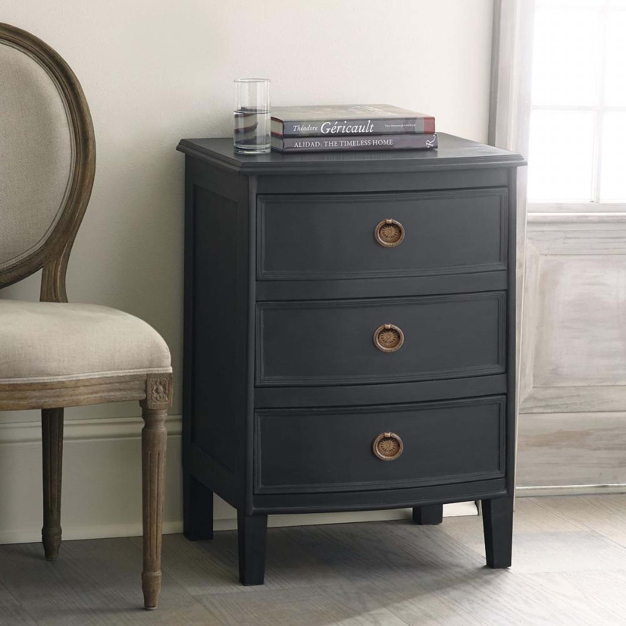 Kunj Three Drawer Chest – Coal finish, styled in bedroom with books and chair, soft natural light.