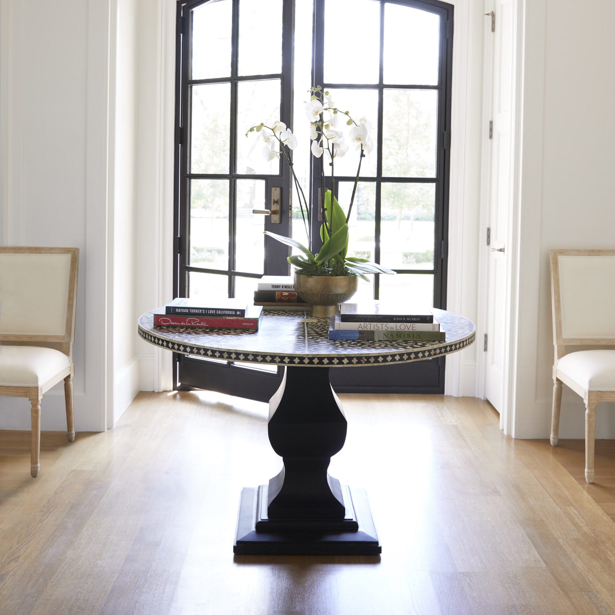 Moorish Dining Table in a Living Room Setting With Flower Vase and Books on Top