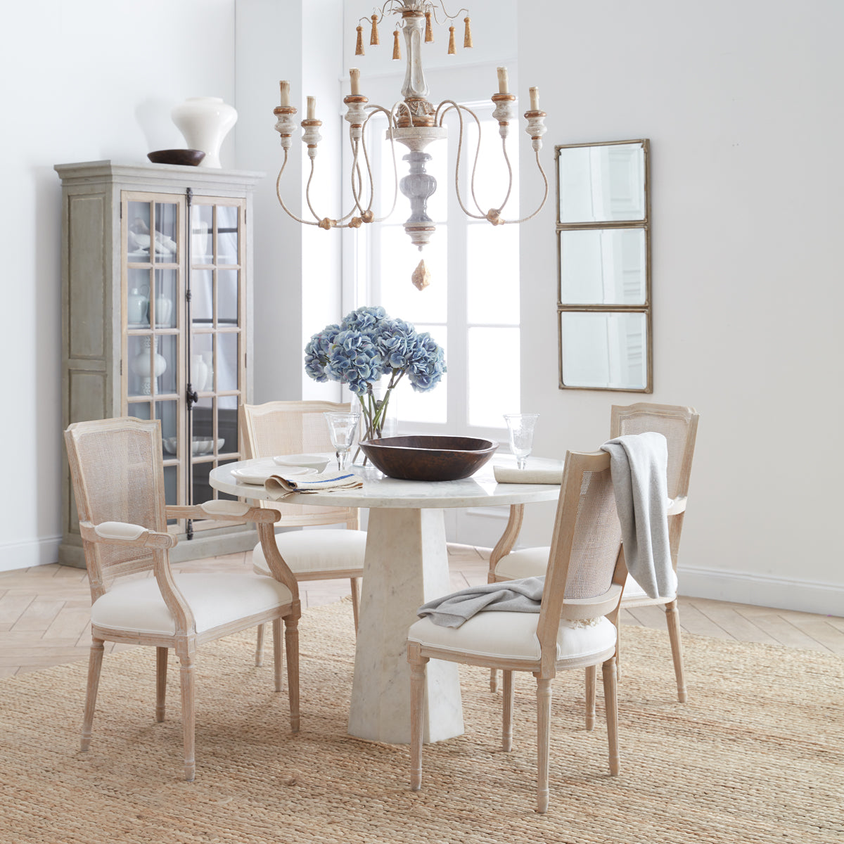 Faceted Marble Table in a room setting with flowers in a vase on top